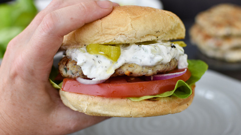 Chicken hamburger with creamy sauce on bun.