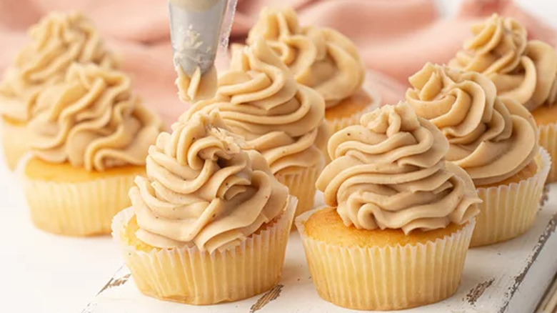 Cupcakes with piped, light brown frosting swirls