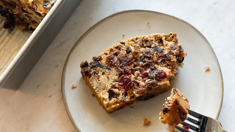 Fruit cake slice with piece on a fork