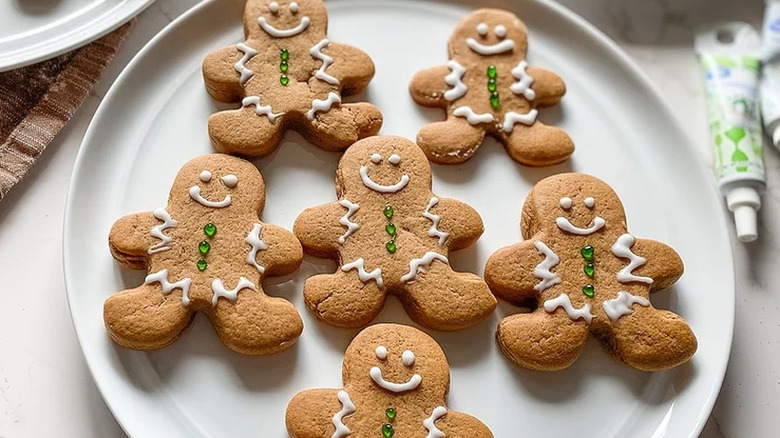 Six decorated gingerbread men on plate.