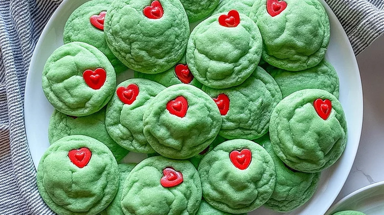 Round green cookies with heart-shaped candies.