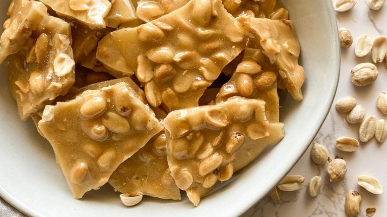Pieces of hard peanut brittle candy in a bowl