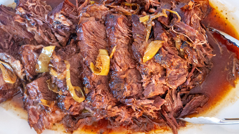 Platter of pot roast with tongs