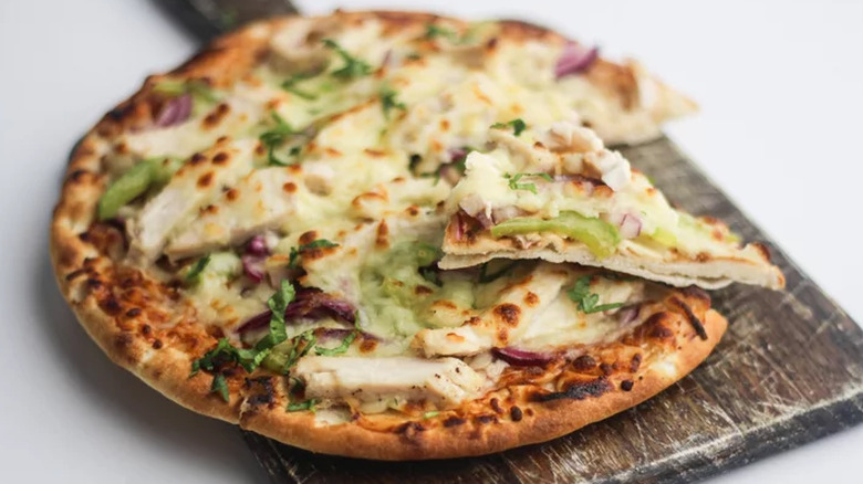 Round chicken pizza on wood paddle