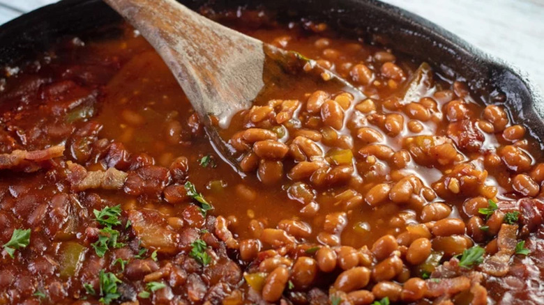 Beans in sauce with wooden spoon