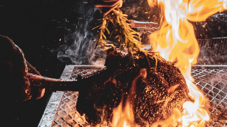 Tomahawk steak over a flaming grill