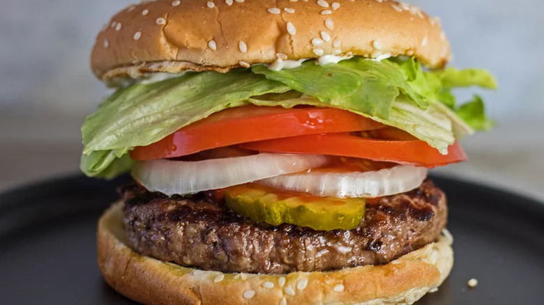 Burger with lettuce, tomato, and onion
