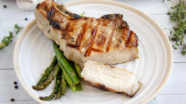 Grilled pork chop and asparagus on a plate
