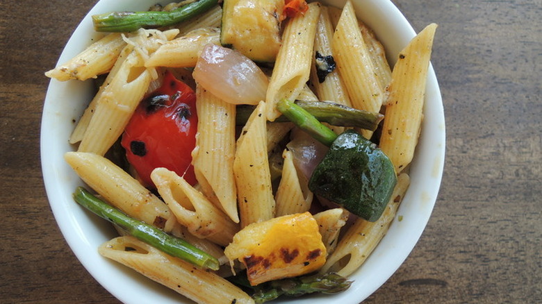 white bowl of pasta and grilled veggies