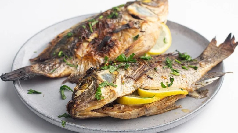 Grilled whole fish stuffed with lemon slices
