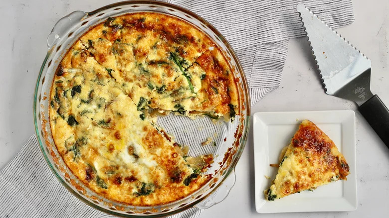 A baking tray of quiche with a slice 