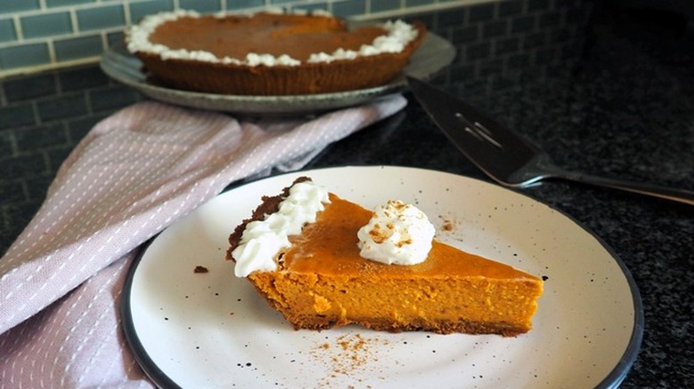 Slice of pumpkin pie with whipped cream