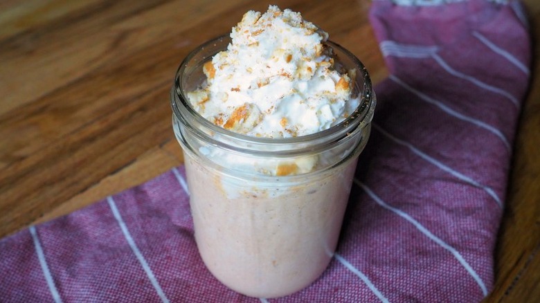 Glass jar with blended ice cream and whipped cream