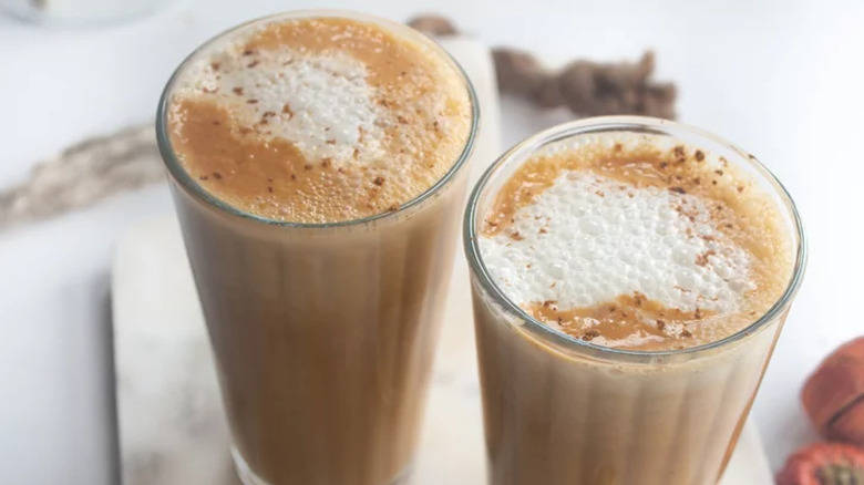 Two tall glasses of creamy coffee drinks