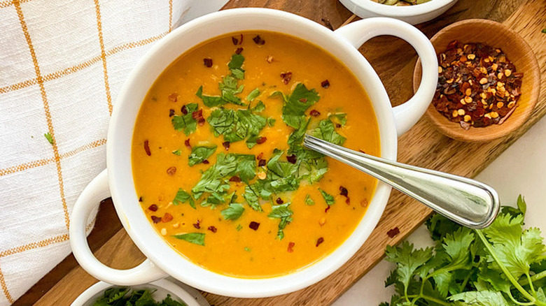 White crock of pumpkin soup with cilantro