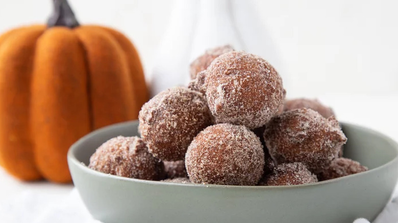 Bowl of donut holes with pumpkin in background