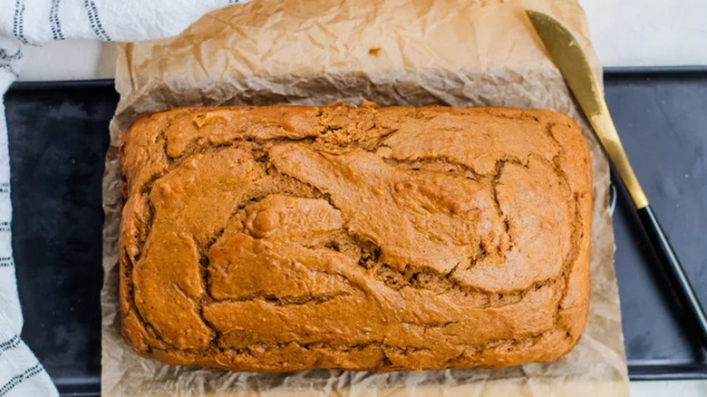 Loaf of baked pumpkin bread with knife