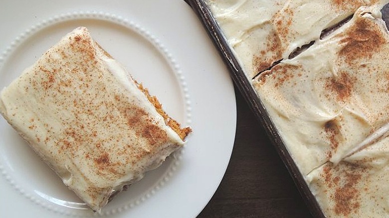 Square slice of frosted cake with cinnamon dusting