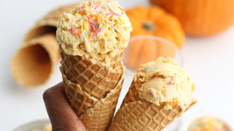 Two waffle cones with ice cream and sprinkles