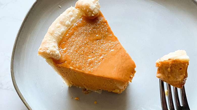 Pumpkin pie slice with a forkful out