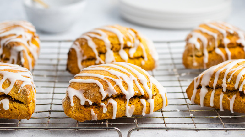 Iced pumpkin scones on a cooling rack.