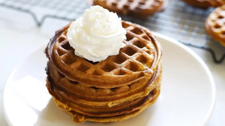 Stack of orange-brown pancakes with butter