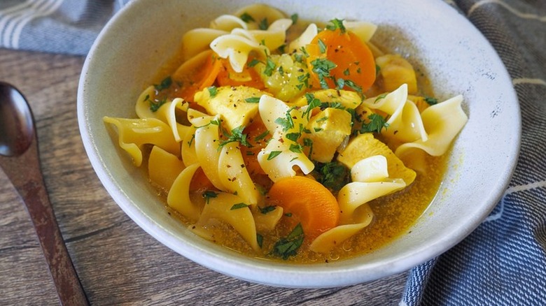 Chicken soup with noodles, carrots and parsley