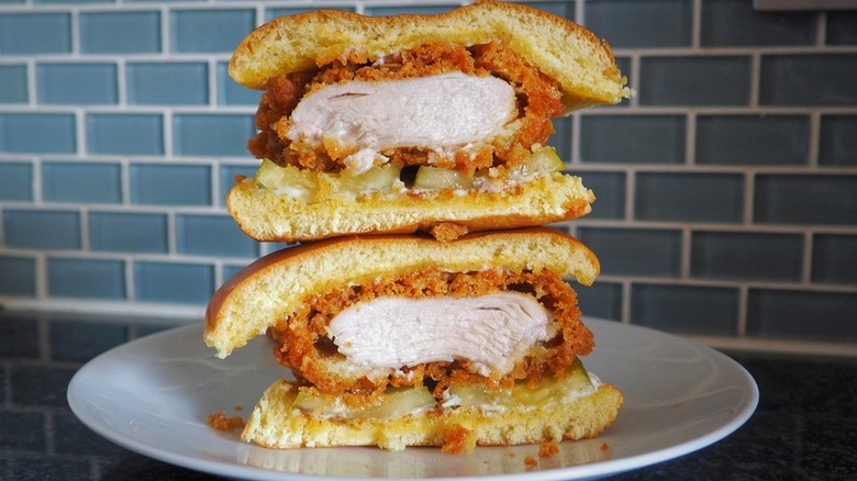 Two thick fried chicken sandwiches on top of each other cut in half