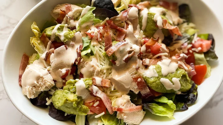 Salad with bacon, chicken and dressing