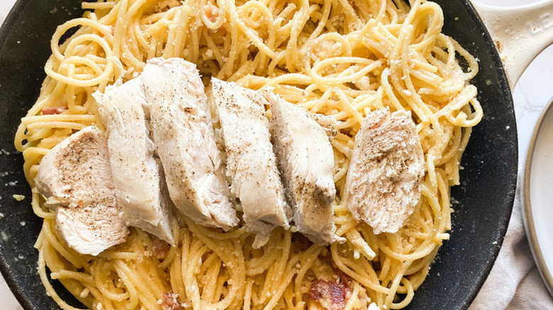 Sliced chicken over pasta with Parmesan cheese