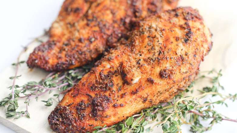 Browned chicken breasts on thyme sprigs