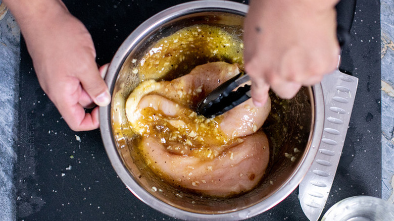 Raw chicken in a diced garlic marinade