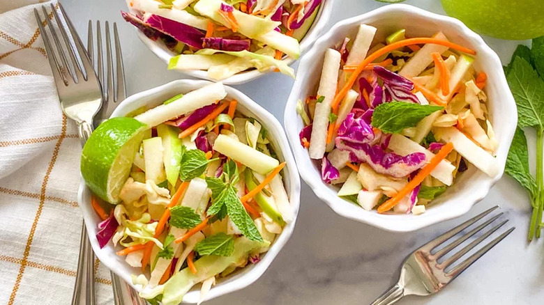 Small bowls of slaw salad with lime, apple, and jicama. 