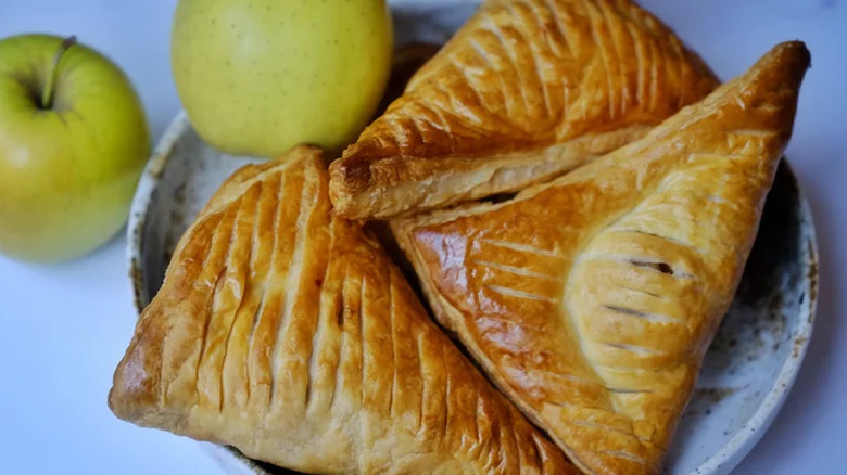 Shiny apple pastry triangles with scored crust.