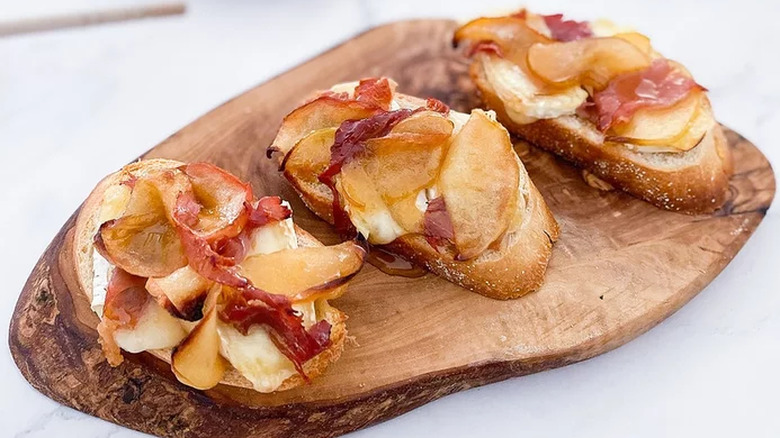 Baguette slices, prosciutto, and apple.