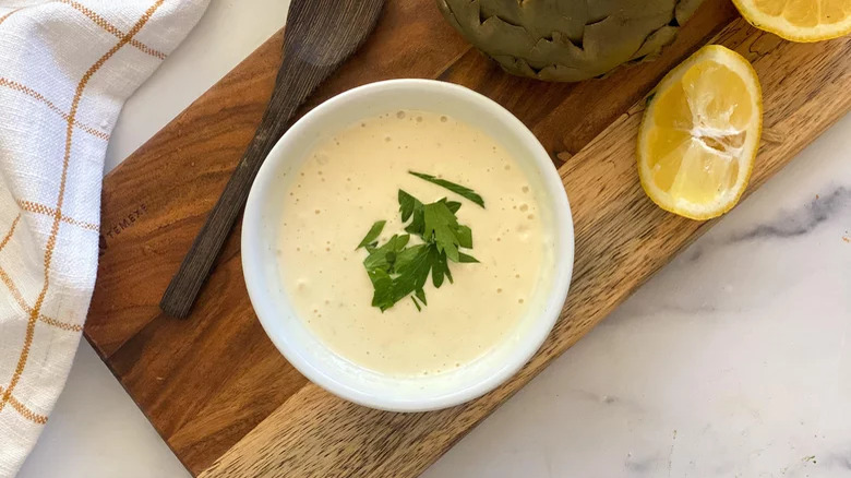 Garlic Aioli on board with lemon and spoon