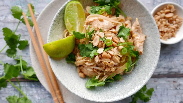 Spicy Pad Thai with peanuts and lime and chopsticks