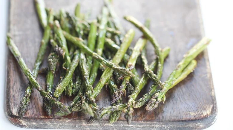 wooden cutting board with air fryer roasted asparagus