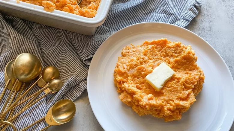plate of creamy mashed sweet potatoes with butter and measuring spoons