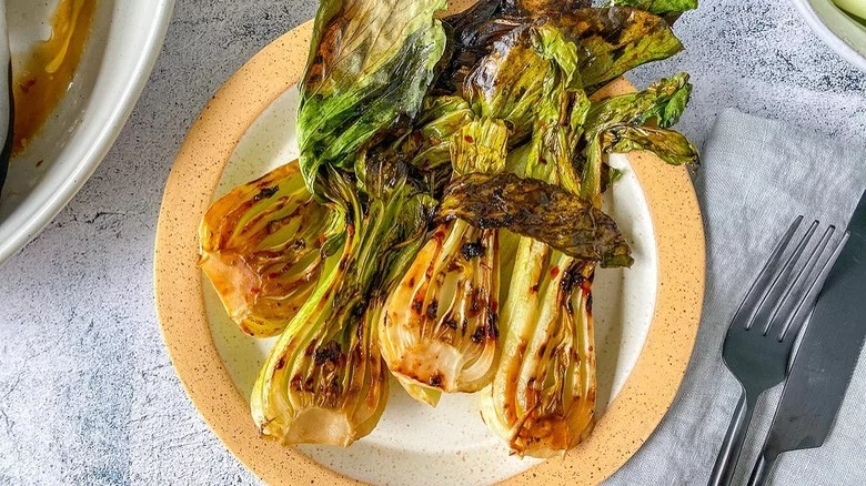 plate of grilled bok choy with knife and fork
