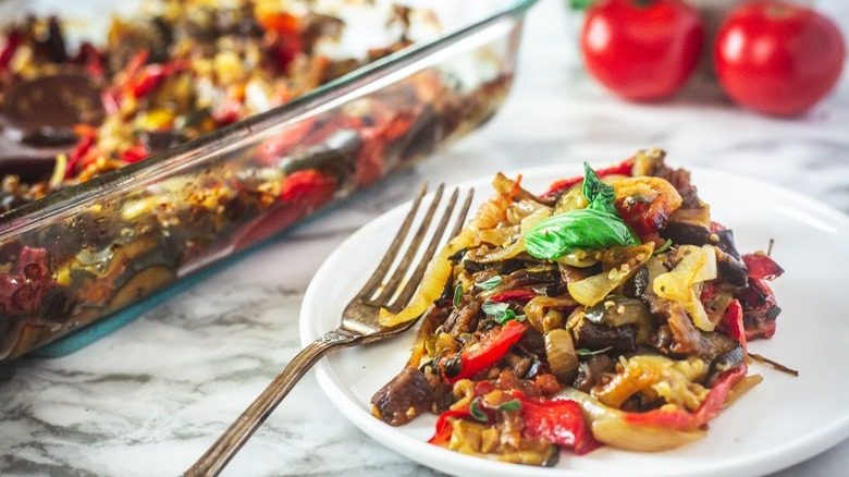 plate of ratatouille with fork and tomatoes