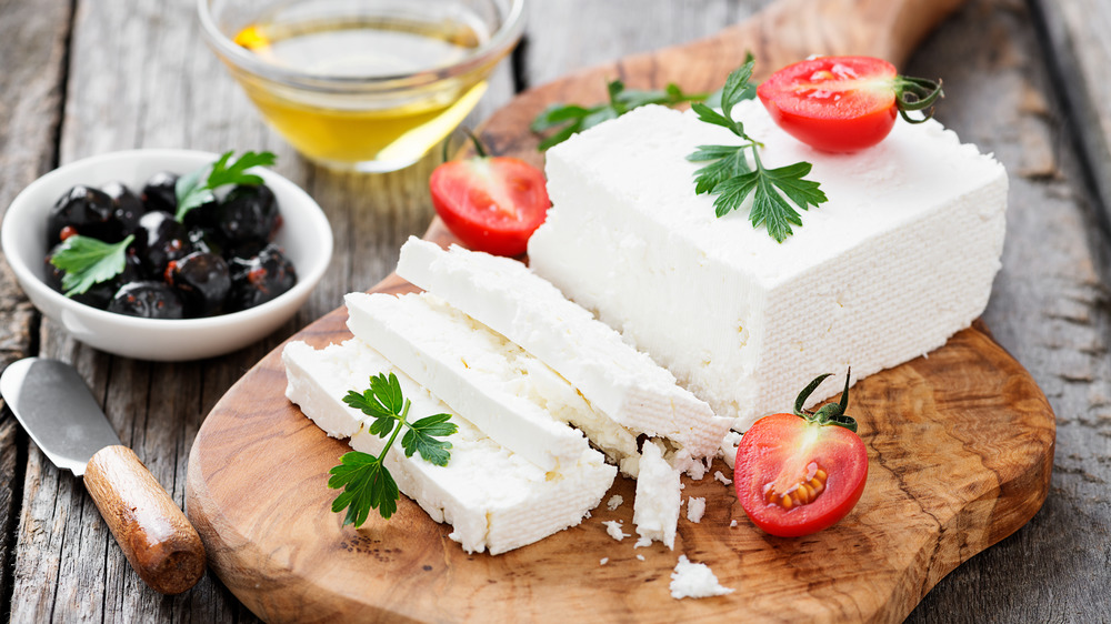 feta cheese on a board with tomatoes