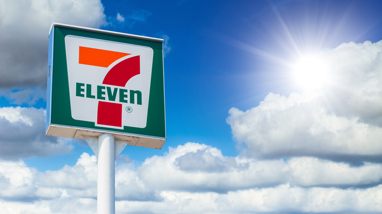 7-Eleven sign against blue sky and clouds