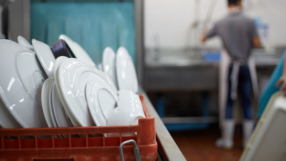 man cleaning dishes of food