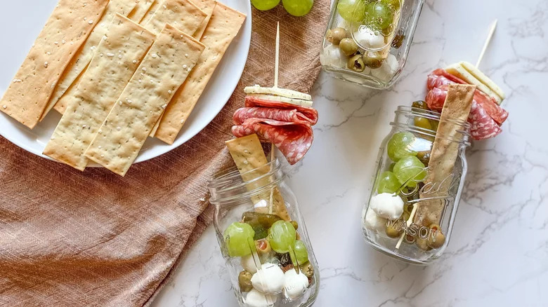 crispbread and grapes with cold cuts, mozzarella and ball skewer jar