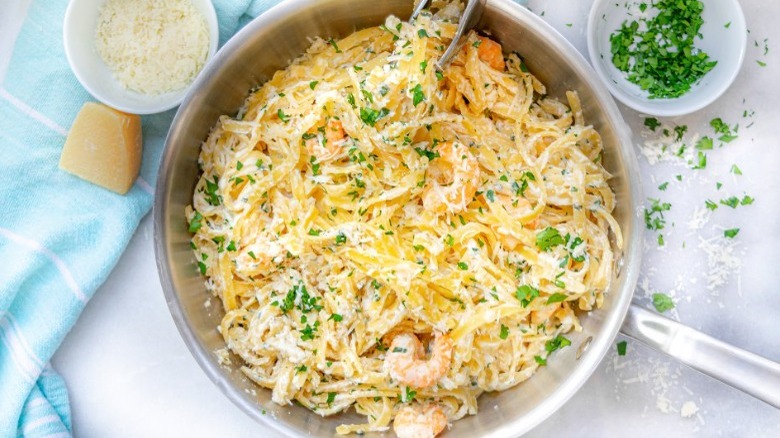 pot of shrimp alfredo pasta with cheeses and garnish