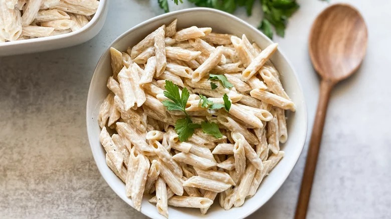 bowl of creamy garlic butter pasta with wooden spoon