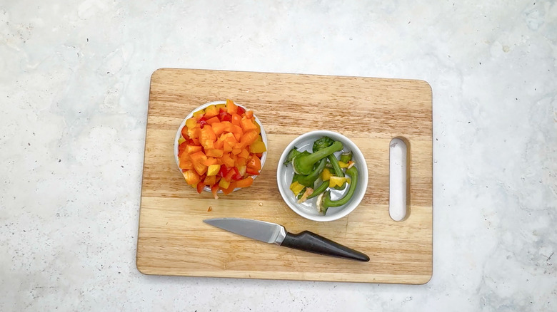 sliced bell pepper caps and stems on cutting board