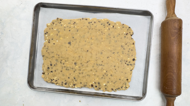 cookie dough rolled out on rimmed sheet