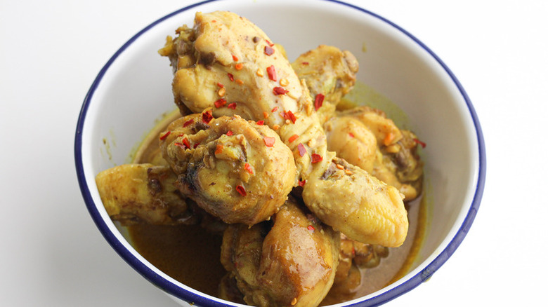 chicken drumsticks in white bowl